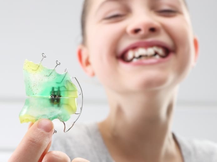 Child holding her retainer